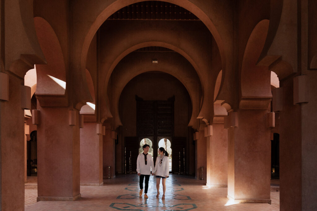 two people walking in a hallway of Aman jana hotel marrakech