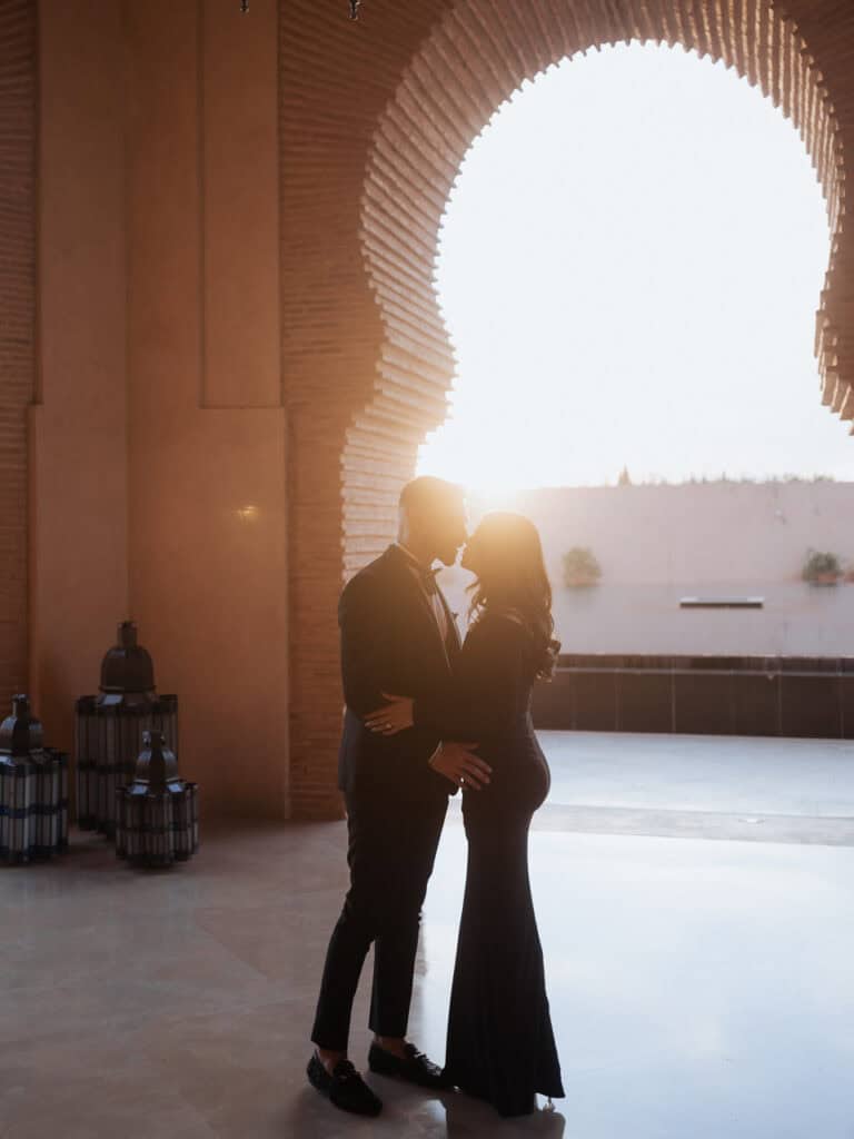 pre-wedding photography in Marrakech, åa man and woman kissing in front of a arch