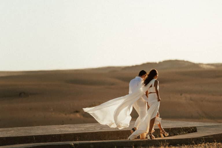 Sendy and Paul walking through the Agafay desert at sunset before their Beldi Country Club wedding