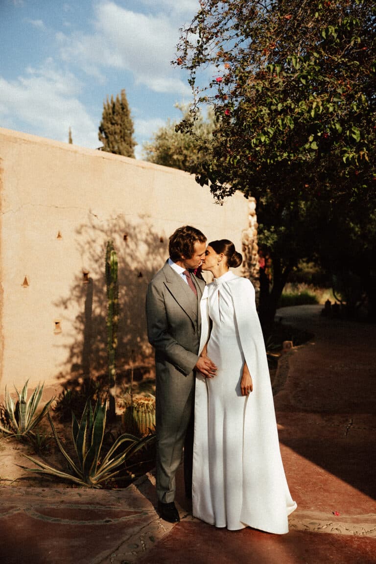 Aude and Charles kissing in the gardens of Beldi Country Club in Marrakech.